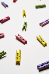 A lot of multi-colored village clothespins on a b background, close-up