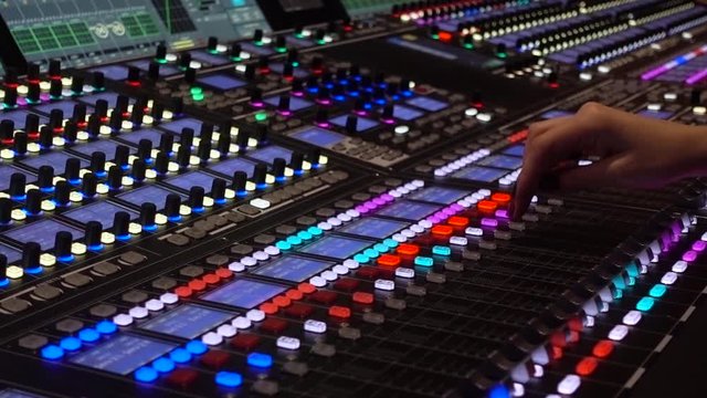 Professional tool sound engineer in the studio or at a concert. Telecommunication. Musical digital mixer to adjust the scene close-up. Hand woman