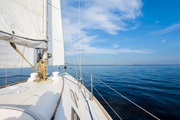 White sloop rigged yacht sailing near the coast of Maine, Southwest Harbor, USA. A view from the...