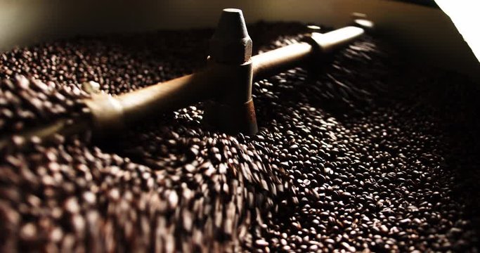 Spinning brass paddle cools down coffee beans in roasting process with natural sunlight