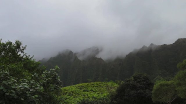 clouds sweeping over mountains with rainfall in fore ground