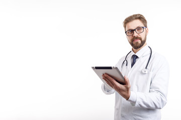 Cheerful slightly smiling bearded doctor with tablet and stethoscope looking at camera isolated white background copyspace