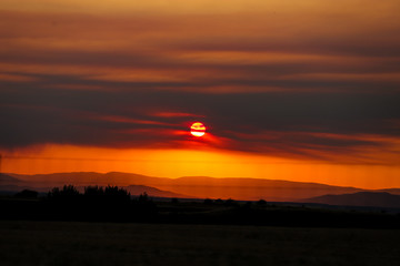 Atardecer entre las montañas y los árboles de un paisaje de España