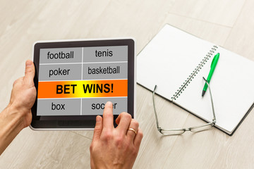 casino, online gambling, technology and people concept - close up of poker player hands with playing cards, tablet pc computer and chips at green casino table