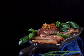 Duck breasts carpaccio cut into thin slices on the black wooden board