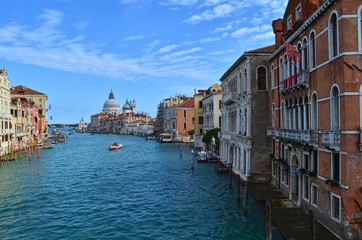 panoramic view of the wide Venetian canal, with the domes of the Basilica Della Salute in the background