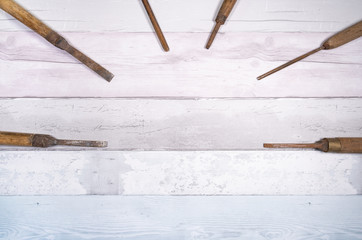 Assortment of old wood chisels on a background of old boards. Top view