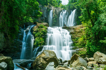 The tapering Nauyaca Waterfalls in Costa rica, a majestic cascading fall in Dominical province, Costa Rica - obrazy, fototapety, plakaty