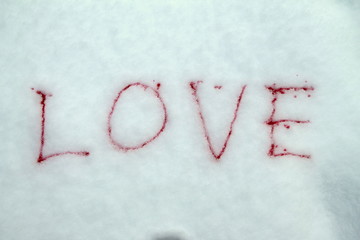 Word love painted with red paint on snow symbol of love postcard for Valentines Day