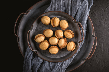 Homemade cookies shaped nuts with cream boiled condensed milk on dark background