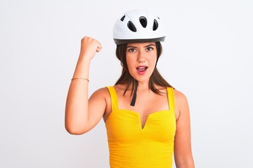 Young beautiful cyclist girl wearing bike helmet standing over isolated white background annoyed and frustrated shouting with anger, crazy and yelling with raised hand, anger concept