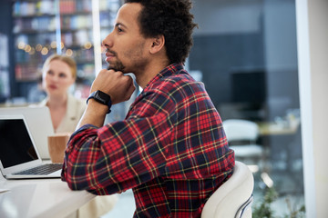 Afro american man sitting at the table with notebook