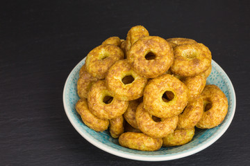 sweet and salty snack - corn puff donuts with peanuts and caramel in a bowl