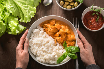 Indian curry chicken with basmati rice in bowl with spices and herbs