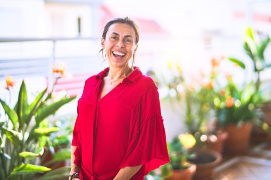 Middle age beautiful woman smiling happy and confident standing with a smile on face at terrace