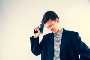 Young man in a business jacket with a gun reflects on something intensely. Thoughtful spy. Copy...