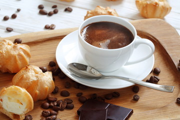 Profiteroles with coffee and chocolate on a white background