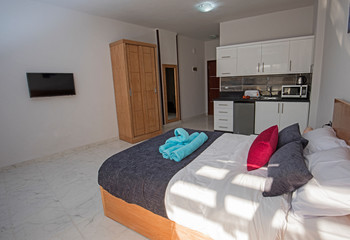 Interior design of bedroom in studio apartment with kitchen