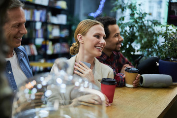 Joyful business colleagues having coffee break at work