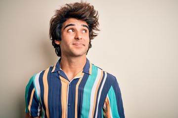Obraz premium Young man on vacation wearing summer colorful shirt standing over isolated white background smiling looking to the side and staring away thinking.
