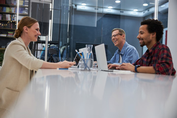 Fototapeta premium Cheerful lady chatting with colleagues in office