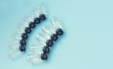 Medicine in vials, ready for vaccine injection on blue background. Cancer, painand diabetes treatment, pharmaceutical medicine concept .