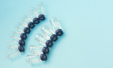 Medicine in vials, ready for vaccine injection on blue background. Cancer, painand diabetes treatment, pharmaceutical medicine concept .