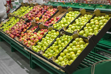 Apples in the cardboard boxes on the grocery shelf