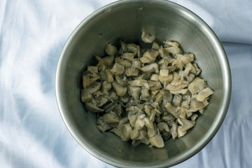 Fried mushrooms in a metal dish on a light background