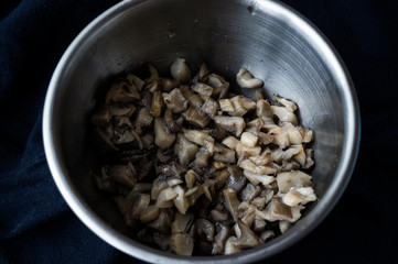 Fried mushrooms in a metal dish on a dark background