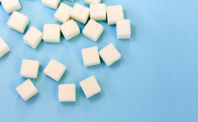 Sugar addiction, insulin resistance, unhealthy diet, sugar cubes on blue background, diabetes protection concept, top view.