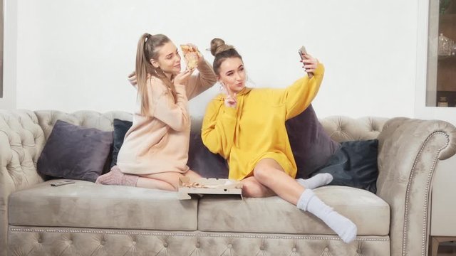 girls taking selfies with pizza