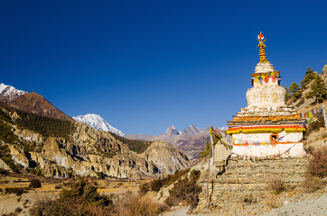 White stupa on the trekking route in Marshyangdi river valley between near Bhraka (Braga) village....