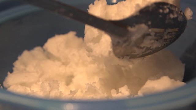 Shea butter being added for cannabis salve oil preparation, close up