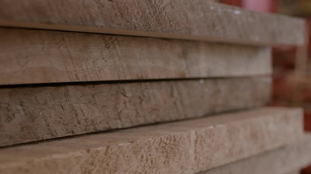 Stack of freshly cut planks of wood with nice texture close up tracking right