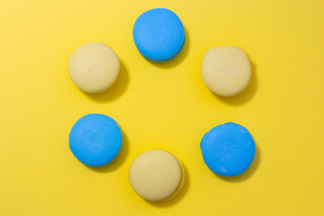 macaroni cookies laid out in a circle on a bright yellow background with copy space