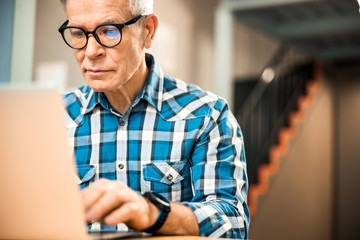 Mature male working with laptop at workplace