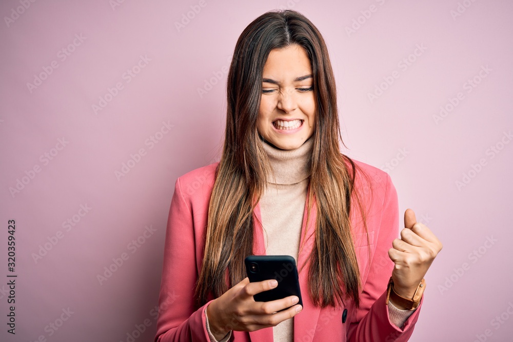 Wall mural young beautiful girl having conversation using smartphone over white background annoyed and frustrat