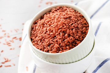 Uncooked red  rice Dev-zira in bowls on the table, light background, free space for text. Rice for...
