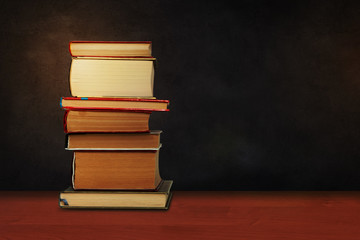 Back to school, pile of books with empty green school board background, education concept.