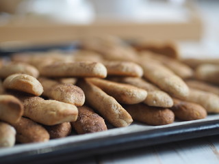 Homemade shortbread biscuits with cinnamon and nuts on a black baking sheet for the oven. We bake cookies.
