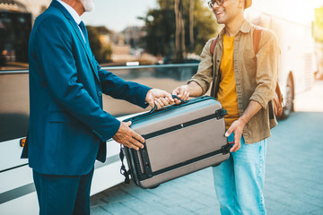 The bus driver accepts luggage from passenger.