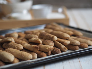 Homemade shortbread biscuits with cinnamon and nuts on a black baking sheet for the oven. We bake cookies.