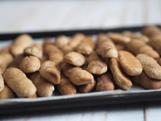 Homemade shortbread biscuits with cinnamon and nuts on a black baking sheet for the oven. We bake cookies.