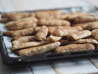 Homemade shortbread biscuits with cinnamon and nuts on a black baking sheet for the oven. We bake cookies.