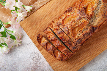 Pooppy cake with apple on wooden plate. Sliced pie.