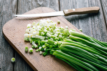 Sliced Fresh green onions on a wooden cutting board