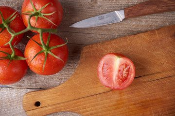 Fresh raw tomatoes over wooden background