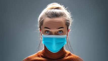 Woman wearing blue medical protective mask to health protection from influenza virus, epidemic and infectious diseases - obrazy, fototapety, plakaty