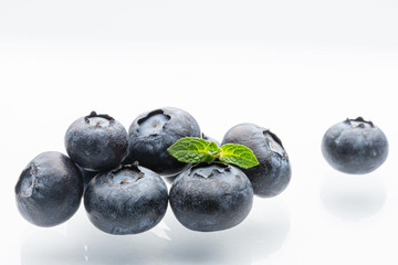 Ripe blueberries on a white background. A sprig of fresh mint. Berries. White background. Blue. Garden berries. Isolated.